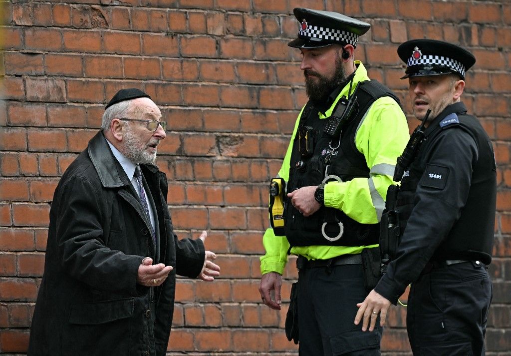Rendőrök beszélnek a helyi zsidó közösség egyik tagjával a manchesteri támadás után
