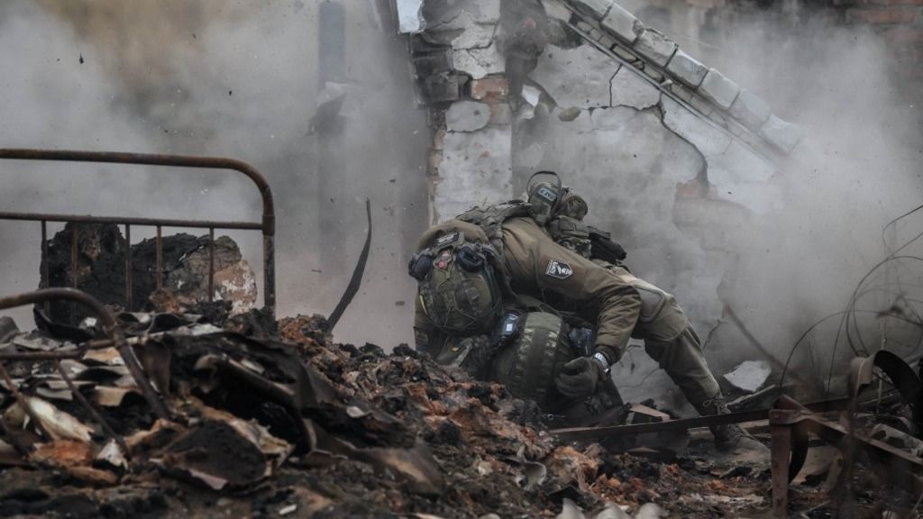 Infantry recruits of the 28th Seperate Mechanized Brigade take cover from a grenade blast as they undergo a basic training course at an undislosed location in eastern Ukraine on October 9, 2025. (Photo by Ed JONES / AFP)