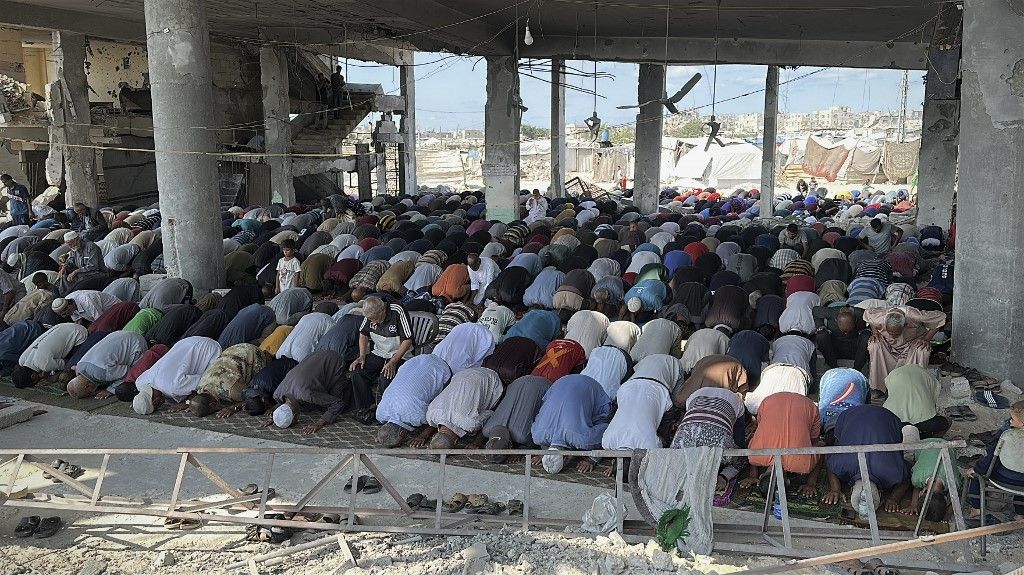 Palestinian Muslim worshippers attend friday prayers amidst the rubble of the destroyed Albaani Mosque in Khan Yunis in the southern Gaza Strip on October 17, 2025. Hamas said it was committed to the US-brokered agreement that halted its war with Israel, and to returning all the bodies of hostages still unaccounted for under the ruins of Gaza. (Photo by Doaa Albaz / Middle East Images via AFP)