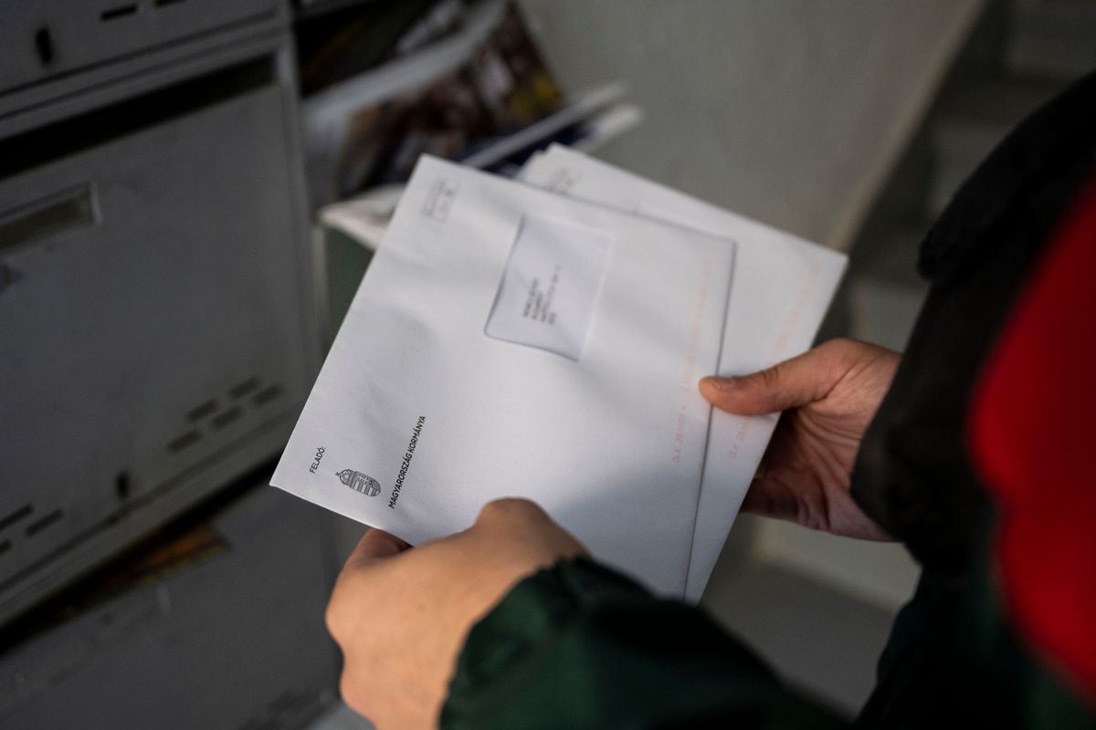 A nemzeti konzultáció kérdőíveit kézbesíti egy postás egy budapesti társasházban 2025. október 1-jén