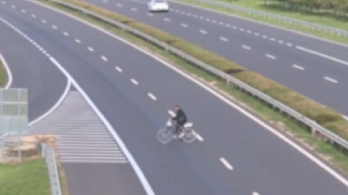 Kerékpárral kelt át valaki a szalagkorláttal elválasztott M30-as autóúton + videó