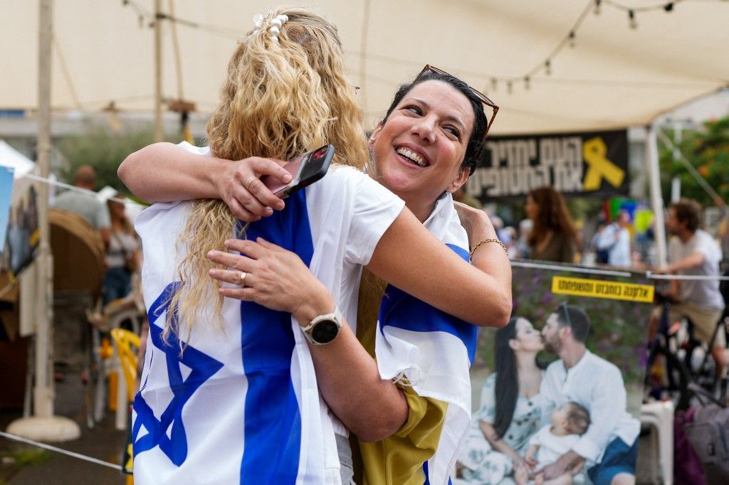 People reacts at Hostage Square in Tel Aviv on October 9, 2025, following news of a new Gaza ceasefire deal. Israel and Hamas on October 9 agreed a Gaza ceasefire deal to free the remaining living hostages, in a major step towards ending a war that has killed tens of thousands of people and unleashed a humanitarian catastrophe. (Photo by MAYA LEVIN / AFP)