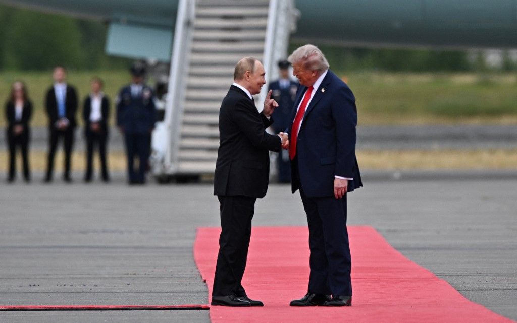In this pool photograph distributed by the Russian state agency Sputnik, US President Donald Trump greets Russian President Vladimir Putin on the tarmac after they arrived for a meeting on Ukraine at Joint Base Elmendorf-Richardson in Anchorage, Alaska, on August 15, 2025. (Photo by Sergey Bobylev / POOL / AFP)