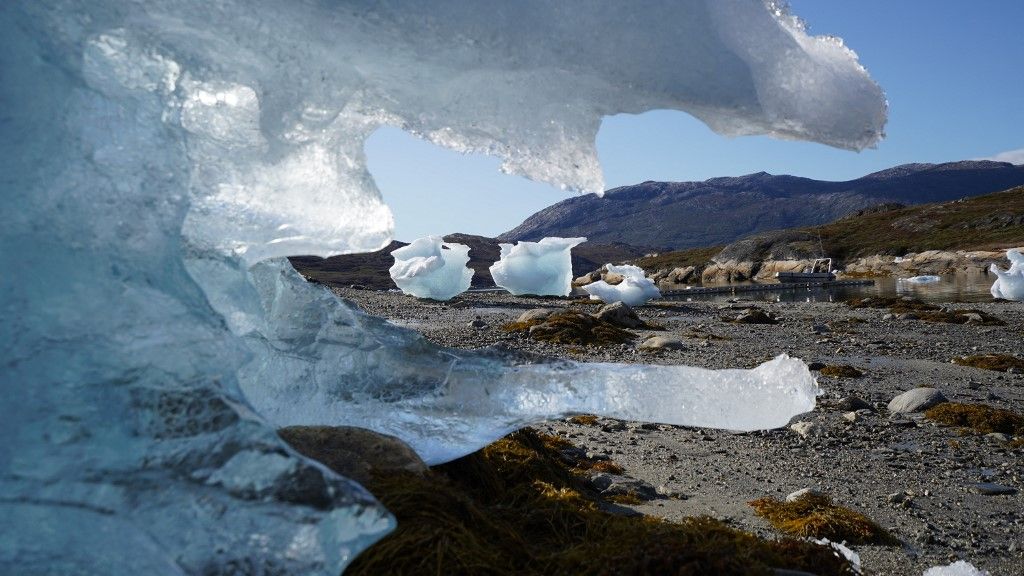 Beached icebergs sit on the shore at Camp Kangiusaq in Nuuk Fjord, Greenland on September 1, 2024. It is a virtually uninhabited territory, covered mainly in ice, and yet, in Greenland, football is king and fans, in search of recognition, want to be able to measure themselves against other nations, a chimera as long as they have not joined a continental federation. (Photo by James BROOKS / AFP) / TO GO WITH AFP STORY by James BROOKS