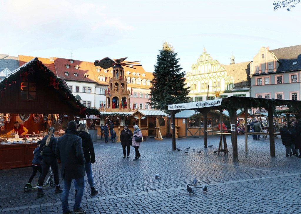 03 January 2023, Thuringia, Weimar: Visitors walk through the still open Christmas market. Weimar is one of the last major open Christmas markets in Thuringia and awaits visitors until 05.01.2023. Photo: Bodo Schackow/dpa (Photo by Bodo Schackow / dpa Picture-Alliance via AFP)