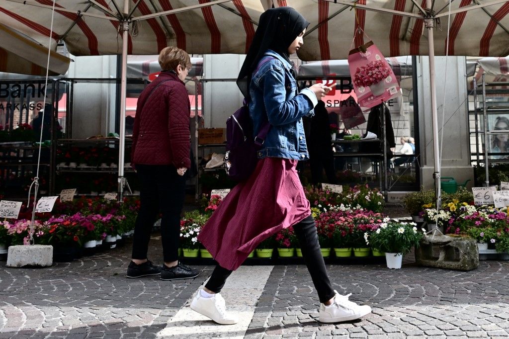 Egy fiatal, fátyolba burkolózott nő sétál Monfalcone utcáján  (Fotó: ALBERTO PIZZOLI / AFP)
