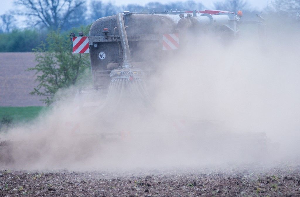15 April 2025, Mecklenburg-Western Pomerania, Kaeselow: A fertilizer truck drives across a field and stirs up a cloud of dust. A lack of rain and strong winds causing the soil to dry out are a growing concern for farmers in northern Germany. Photo: Jens Büttner/dpa (Photo by JENS BUTTNER / dpa Picture-Alliance via AFP), műtrágya