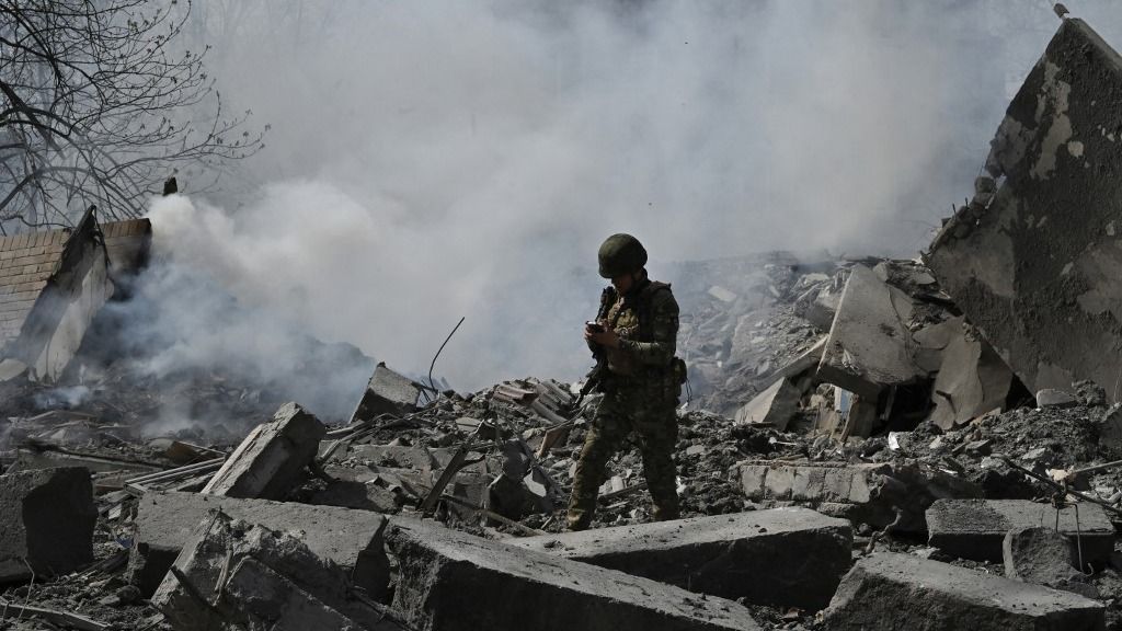 A member of the Ukrainian White Angels Special Police Team walks amongst the debris of a multi-storey residential building, destroyed following an air strike in the frontline town of Avdiivka, Donetsk region on April 10, 2023, amid the Russian invasion of Ukraine. (Photo by Genya SAVILOV / AFP)