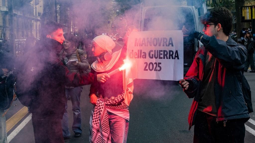 A thousand young people march through the streets of Turin, Italy, on November 14, 2025, initially led by Fridays for Future. At a certain point, the crowd splits into two groups, with the larger group heading toward Porta Nuova station to block the trains. They stay there for a few minutes before being pushed back by the police. (Photo by Mauro Ujetto/NurPhoto) (Photo by Mauro Ujetto / NurPhoto via AFP)