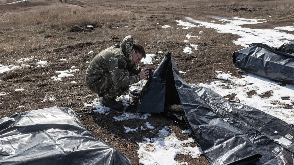 DONETSK OBLAST, UKRAINE - MARCH 2: Volunteers from the Ukrainian organization ‘Platsdarm’ collect and transport the bodies of deceased Russian soldiers from combat positions as part of the efforts to identity of the dead bodies of Russian soldiers, which will later be sent to Russia to be handed over to their families, at an undetermined location in Donetsk Oblast, Ukraine on March 2, 2025. Diego Herrera Carcedo / Anadolu (Photo by Diego Herrera Carcedo / Anadolu via AFP)