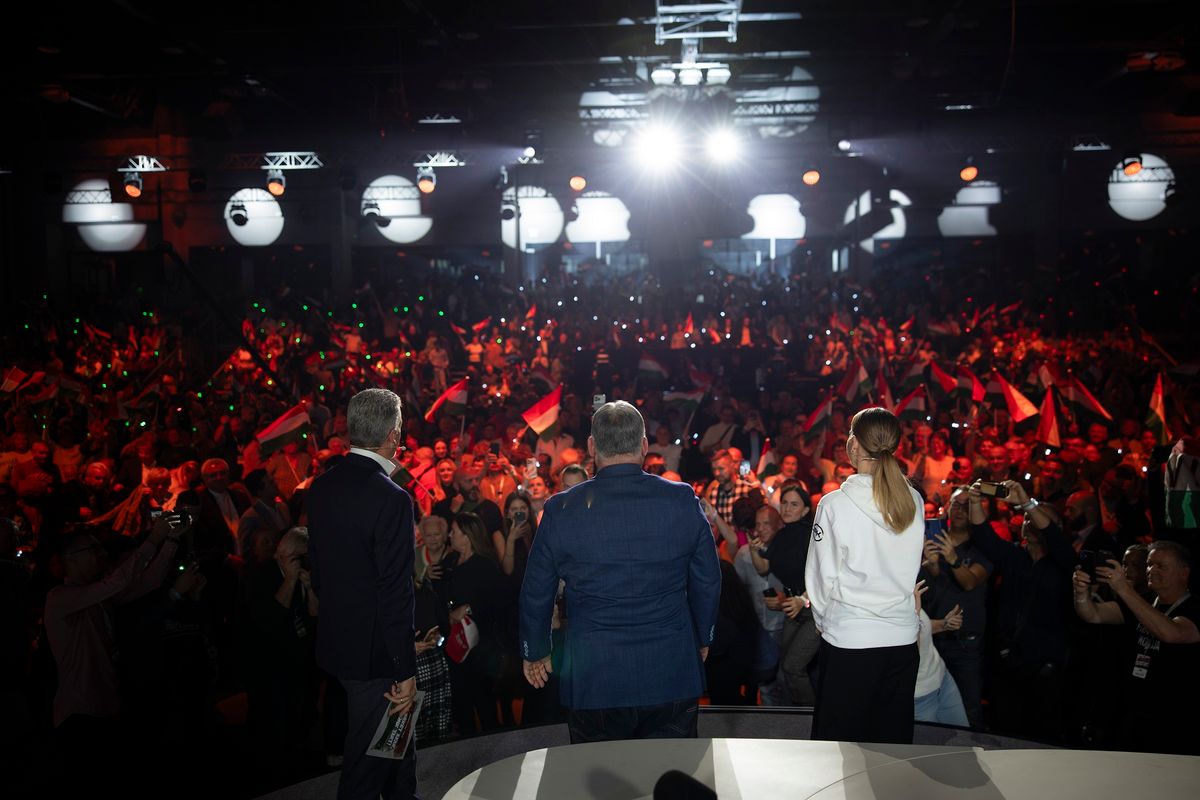 Győr, 2025. november 15.
A Miniszterelnöki Kommunikációs Főosztály által közreadott képen Orbán Viktor miniszterelnök (háttal, k) a digitális polgári körök által szervezett első háborúellenes gyűlésen a győri Olimpiai Sportpark Multicsarnokában 2025. november 15-én. Mellette Rákay Philip producer (b) és Szabó Zsófia színésznő (j), moderátorok.
MTI/Miniszterelnöki Kommunikációs Főosztály/Fischer Zoltán