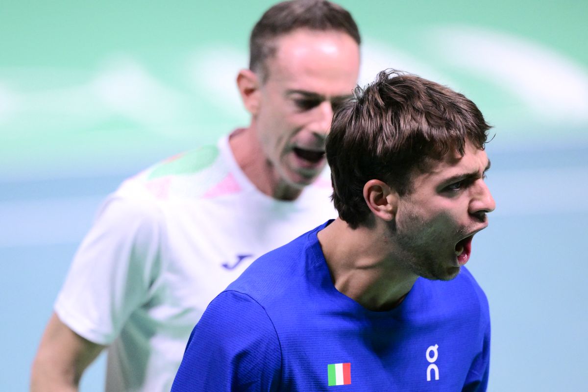 Italy's Flavio Cobolli (R) listens to Italy's team captain Filippo Volandri during a break as he plays against Spain's Jaume Munar Clar during their 2025 Davis Cup men's single final tennis match at the Super Tennis Arena in Bologna, northen Italy, on November 23, 2025. (Photo by Tiziana FABI / AFP)
