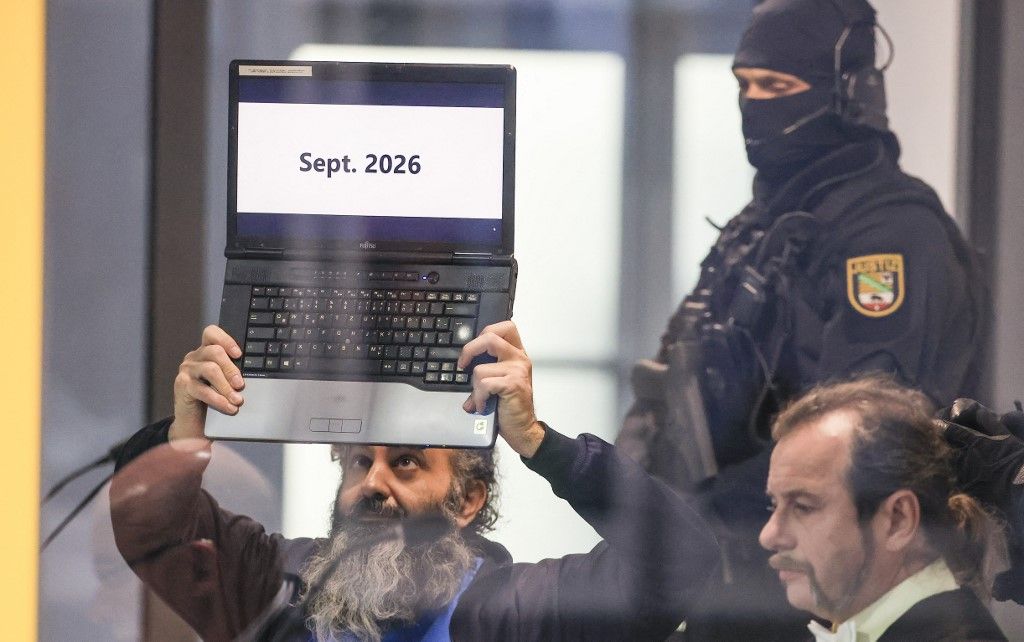 10 November 2025, Saxony-Anhalt, Magdeburg: At the start of the trial, defendant Taleb al-Abdulmohsen holds up his laptop with the inscription "Sept. 2026" in a bulletproof glass box in the courtroom in the temporary court building at Magdeburg District Court. The trial against al-Abdulmohsen begins there this morning. On December 20, 2024, Taleb al-Abdulmohsen drove through the Magdeburg Christmas market. Six people were killed in the attack. In addition, more than 300 people were injured or traumatized. The public prosecutor's office has charged the perpetrator with 338 counts of attempted murder. Photo: Jan Woitas/dpa (Photo by JAN WOITAS / dpa Picture-Alliance via AFP)