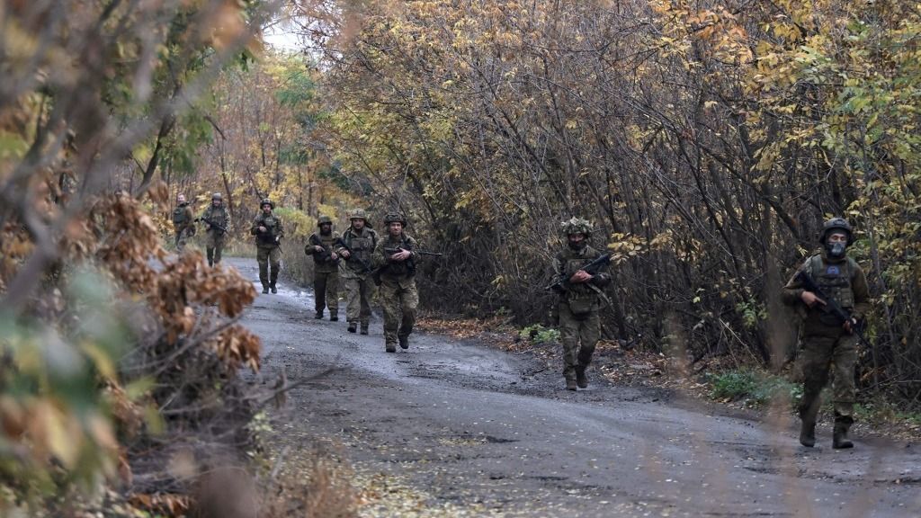 Infantrymen from the 13th Khartiia Brigade of Ukraine's National Guard walk along a dirt road during a loaded march held as part of a drill in Ukraine on October 11, 2025. (Photo by Viacheslav Madiievskyi/Ukrinform/NurPhoto) NO USE RUSSIA. NO USE BELARUS. (Photo by Ukrinform/NurPhoto) (Photo by Viacheslav Madiievskyi / NurPhoto via AFP)