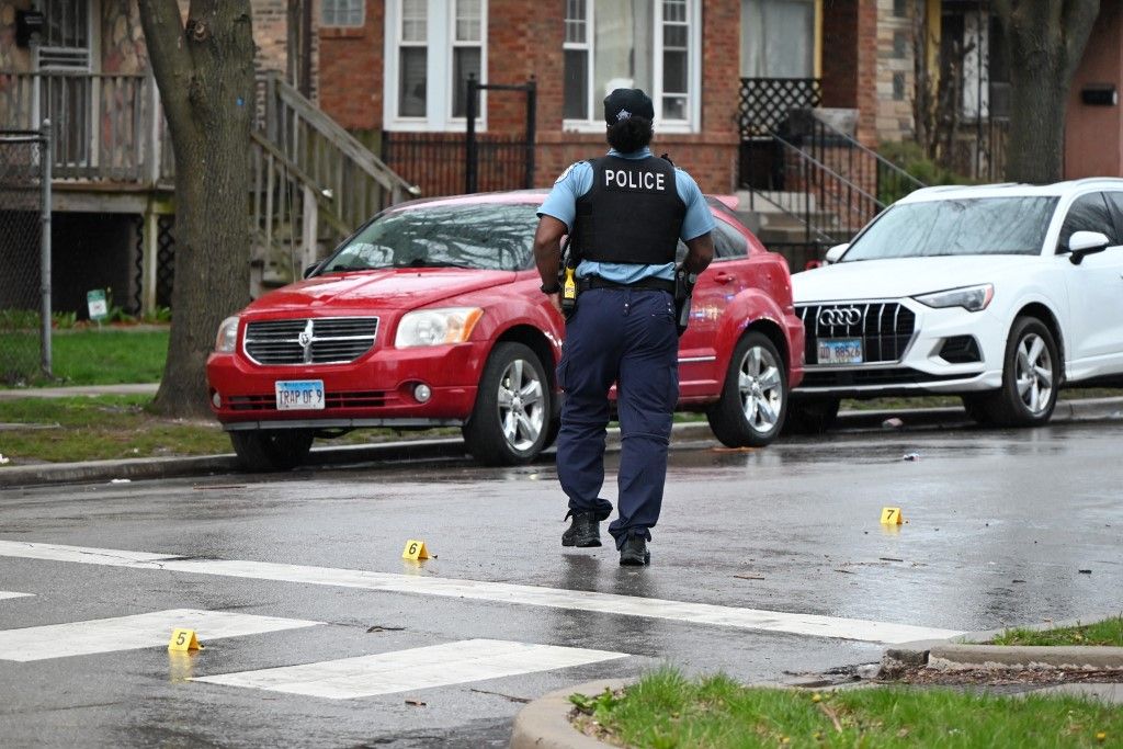 A police officer is at the crime scene where a shooting is injuring a 47-year-old woman in Chicago, Illinois, United States, on April 11, 2024. At approximately 4:55 a.m. on Thursday morning, the woman is telling police that she was outside in the 6700 block of S. Indiana Avenue when she heard shots and then felt pain. The victim is sustaining a gunshot wound to the thigh and is being transported to the hospital in fair condition. No other injuries are being reported, and at this time, no one is in custody. Detectives are investigating the shooting. Multiple shell casings are being found, and several evidence markers are on the ground. (Photo by Kyle Mazza/NurPhoto) (Photo by Kyle Mazza / NurPhoto via AFP)