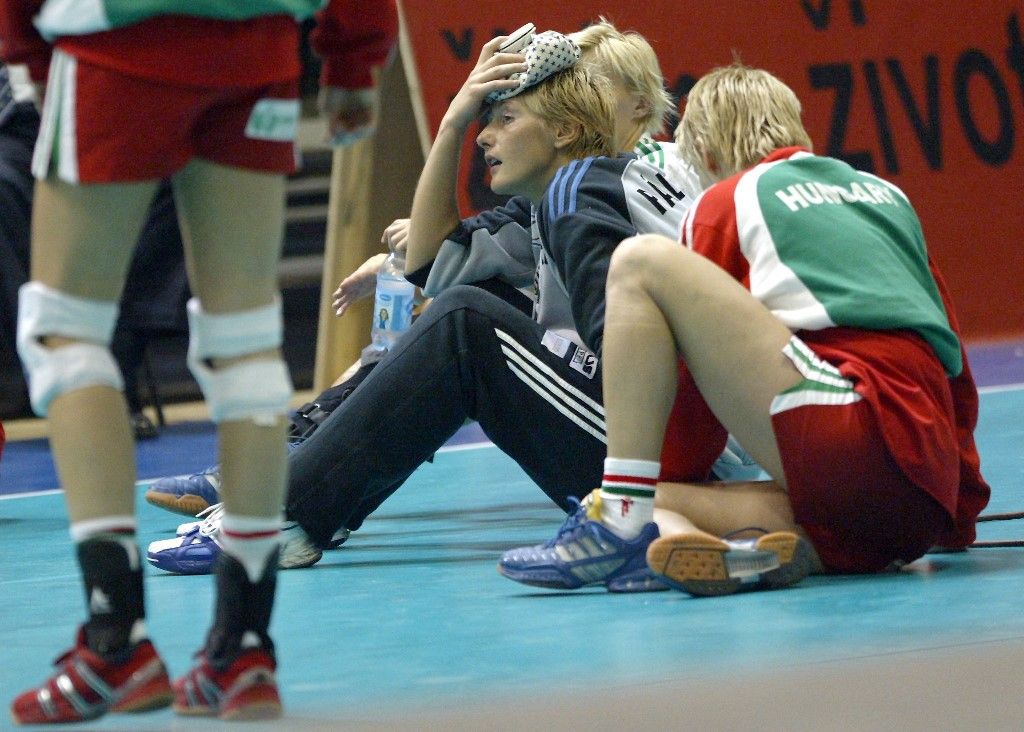 Hungarian players sit on the parquet as Hungary lost the final against France in the 16th Women's World Championships of Zagreb, 14 December 2003. (Photo by ATTILA KISBENEDEK / AFP)