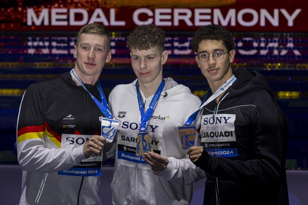 The winners Zalan Sarkany (HUN), second Florian Wellbrock (GER), and Ahmed Jaouadi (TUN) stand after the Men's 800m Freestyle fastest heat at the World Aquatics Swimming Championship (25m) in Duna Arena in Budapest, Hungary, on December 14, 2024. (Photo by Robert Szaniszlo/NurPhoto) (Photo by Robert Szaniszlo / NurPhoto via AFP)