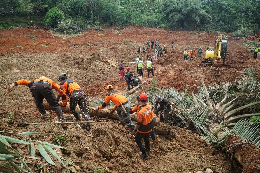 Rescuers search for survivors after a landslide buried some houses in Cibeunying village, Cilacap regency, Central Java, on November 14, 2025. A landslide killed two people and left at least 21 others missing in Indonesia, a disaster official said on November 14. (Photo by Bakhtiar RAHMAN / AFP)