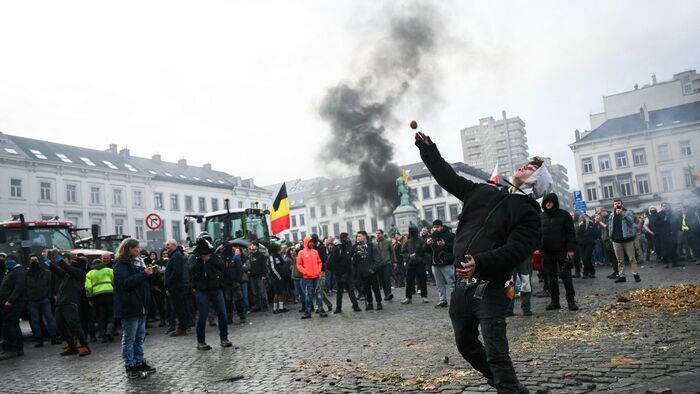 A farmer throws a potato near the European Parliament, during a farmers' protest to denounce the reforms of the Common Agricultural Policy (CAP) and trade agreements such as the Mercosur, in Brussels, on December 18, 2025, organised by Copa-Cogeca, the main association representing farmers and agricultural cooperatives in the EU. EU Farmers, particularly in France, worry the Mercosur deal -- which will be discussed at the EU leaders meeting -- will see them undercut by a flow of cheaper goods from agricultural giant Brazil and its neighbours. They also oppose plans put forward by the European Commission to overhaul the 27-nation bloc's huge farming subsidies, fearing less money will flow their way. (Photo by NICOLAS TUCAT / AFP)