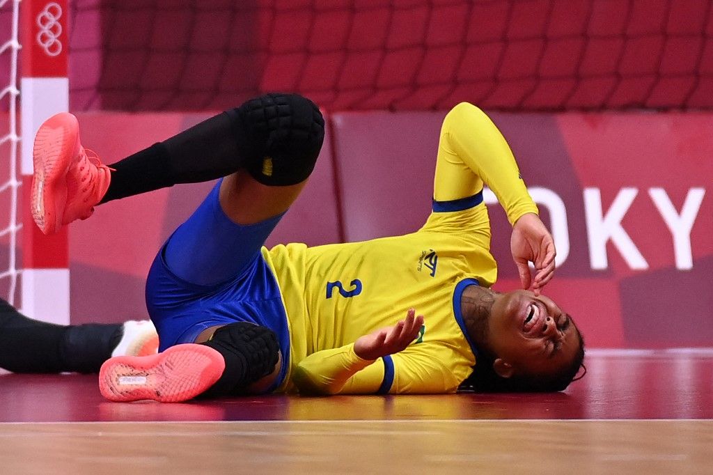 Brazil's right back Bruna De Paula reacts as she lies on the floor during the women's preliminary round group B handball match between Brazil and Hungary of the Tokyo 2020 Olympic Games at the Yoyogi National Stadium in Tokyo on July 27, 2021. (Photo by Daniel LEAL / AFP)