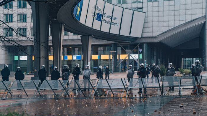 Riot police officers stand in front of the European Parliament, during a farmers' protest to denounce the reforms of the Common Agricultural Policy (CAP) and trade agreements such as the Mercosur, in Brussels, on December 18, 2025, organised by Copa-Cogeca, the main association representing farmers and agricultural cooperatives in the EU. EU Farmers, particularly in France, worry the Mercosur deal -- which will be discussed at the EU leaders meeting -- will see them undercut by a flow of cheaper goods from agricultural giant Brazil and its neighbours. They also oppose plans put forward by the European Commission to overhaul the 27-nation bloc's huge farming subsidies, fearing less money will flow their way. (Photo by EMILE WINDAL / BELGA / AFP) / Belgium OUT