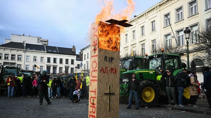 Farmers put on fire a fake coffin with the words "RIP farming" near the European Parliament, during a farmers' protest to denounce the reforms of the Common Agricultural Policy (CAP) and trade agreements such as the Mercosur, in Brussels, on December 18, 2025, organised by Copa-Cogeca, the main association representing farmers and agricultural cooperatives in the EU. EU Farmers, particularly in France, worry the Mercosur deal -- which will be discussed at the EU leaders meeting -- will see them undercut by a flow of cheaper goods from agricultural giant Brazil and its neighbours. They also oppose plans put forward by the European Commission to overhaul the 27-nation bloc's huge farming subsidies, fearing less money will flow their way. (Photo by NICOLAS TUCAT / AFP)