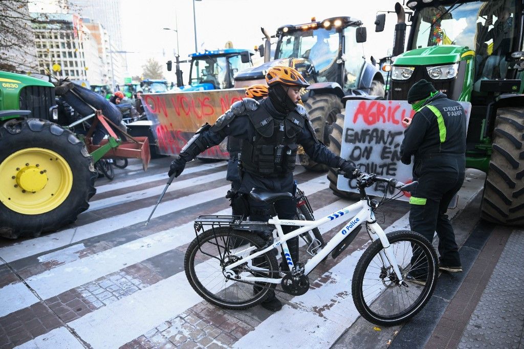 Farmers clash with police officers on bikes near the European Parliament, during a farmers' protest to denounce the reforms of the Common Agricultural Policy (CAP) and trade agreements such as the Mercosur, in Brussels, on December 18, 2025, organised by Copa-Cogeca, the main association representing farmers and agricultural cooperatives in the EU. EU Farmers, particularly in France, worry the Mercosur deal -- which will be discussed at the EU leaders meeting -- will see them undercut by a flow of cheaper goods from agricultural giant Brazil and its neighbours. They also oppose plans put forward by the European Commission to overhaul the 27-nation bloc's huge farming subsidies, fearing less money will flow their way. (Photo by NICOLAS TUCAT / AFP)
