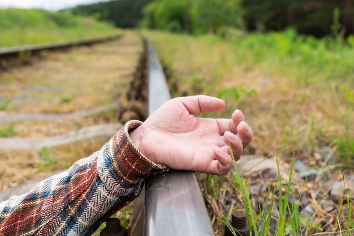 Railway tracks, close-up. Man's hand on rails. Selective focus, noise. Tragedy, accident on the tracks