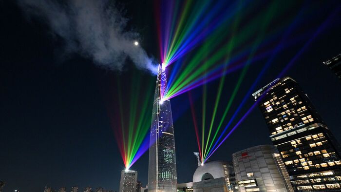 Szilveszter Koreában - Lézerfények világítják meg az éjféli eget a Lotte World Tower, Dél-Korea legmagasabb épülete felett Szöulban a 2026. január 1-jei újévi ünnepség alatt.