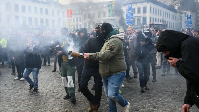 Farmers use a pyrotechnic device in front of the European Parliament, during a farmers' protest to denounce the reforms of the Common Agricultural Policy (CAP) and trade agreements such as the Mercosur, in Brussels, on December 18, 2025, organised by Copa-Cogeca, the main association representing farmers and agricultural cooperatives in the EU. EU Farmers, particularly in France, worry the Mercosur deal -- which will be discussed at the EU leaders meeting -- will see them undercut by a flow of cheaper goods from agricultural giant Brazil and its neighbours. They also oppose plans put forward by the European Commission to overhaul the 27-nation bloc's huge farming subsidies, fearing less money will flow their way. (Photo by NICOLAS TUCAT / AFP)