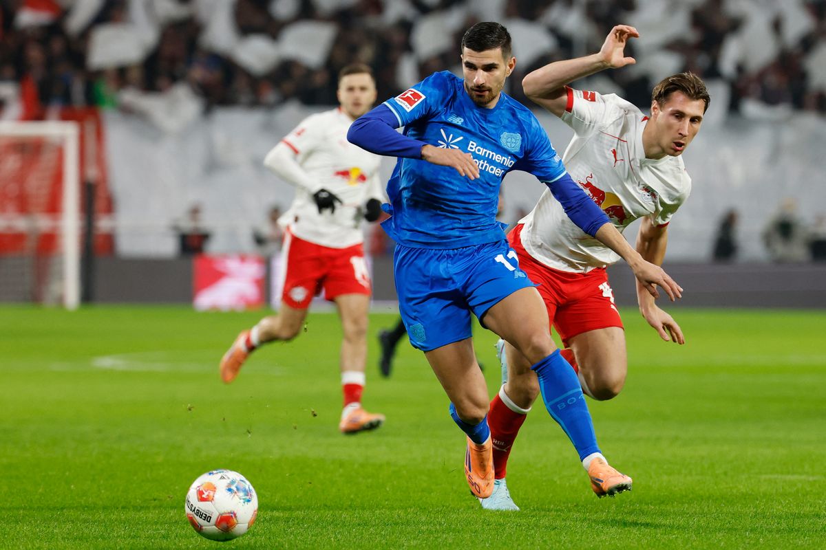 Bayer Leverkusen's French forward #11 Martin Terrier (L) and Leipzig's Hungarian defender #04 Willi Orban vie for the ball during the German first division Bundesliga football match between RB Leipzig and Bayer 04 Leverkusen in Leipzig, eastern Germany, on December 20, 2025. (Photo by Odd ANDERSEN / AFP) / DFL REGULATIONS PROHIBIT ANY USE OF PHOTOGRAPHS AS IMAGE SEQUENCES AND/OR QUASI-VIDEO