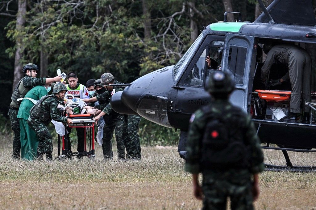 An injured person is taken to a military helicopter during clashes along the Thai-Cambodia border in Thailand's Surin province on December 10, 2025. Half a million evacuees in Cambodia and Thailand were sheltering in pagodas, schools and other safe havens on December 10, 2025 after fleeing renewed fighting in a century-old border dispute in which US President Donald Trump has vowed to again intercede. (Photo by Lillian SUWANRUMPHA / AFP)