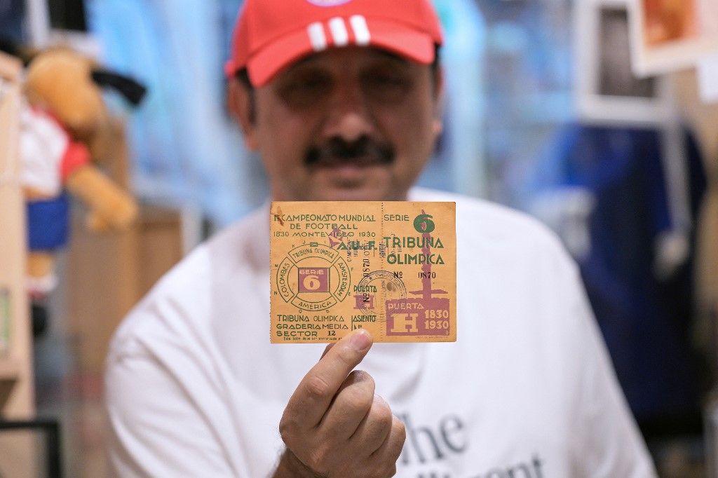 Kuwaiti sports historian Hussein al-Bloushi holds the first ticket ever issued for the 1930 FIFA World Cups opening match in Uruguay, part of his personal collection at his private soccer museum in Kuwait City, on December 8, 2025, which features more than 10,000 rare sports artifacts meticulously collected over the years. (Photo by YASSER AL-ZAYYAT / AFP)