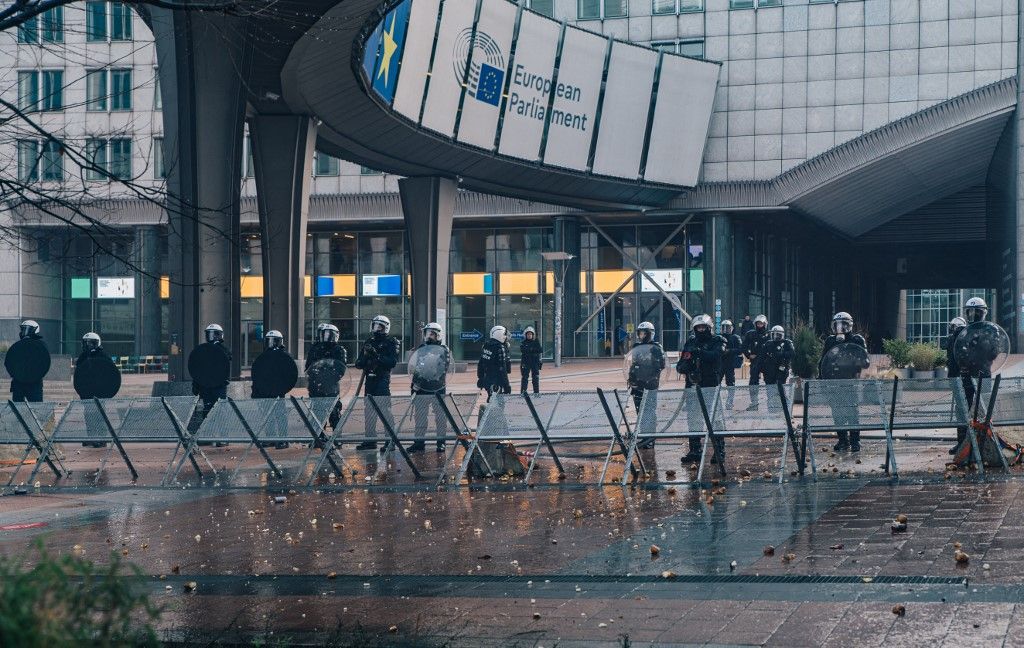 Riot police officers stand in front of the European Parliament, during a farmers' protest to denounce the reforms of the Common Agricultural Policy (CAP) and trade agreements such as the Mercosur, in Brussels, on December 18, 2025, organised by Copa-Cogeca, the main association representing farmers and agricultural cooperatives in the EU. EU Farmers, particularly in France, worry the Mercosur deal -- which will be discussed at the EU leaders meeting -- will see them undercut by a flow of cheaper goods from agricultural giant Brazil and its neighbours. They also oppose plans put forward by the European Commission to overhaul the 27-nation bloc's huge farming subsidies, fearing less money will flow their way. (Photo by EMILE WINDAL / BELGA / AFP) / Belgium OUT