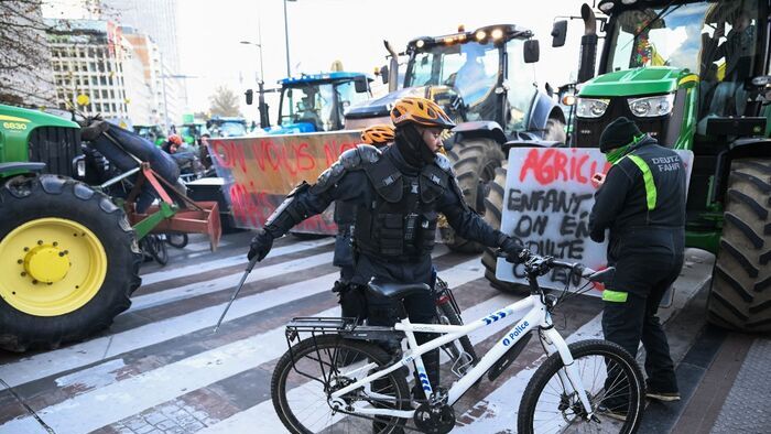 Farmers clash with police officers on bikes near the European Parliament, during a farmers' protest to denounce the reforms of the Common Agricultural Policy (CAP) and trade agreements such as the Mercosur, in Brussels, on December 18, 2025, organised by Copa-Cogeca, the main association representing farmers and agricultural cooperatives in the EU. EU Farmers, particularly in France, worry the Mercosur deal -- which will be discussed at the EU leaders meeting -- will see them undercut by a flow of cheaper goods from agricultural giant Brazil and its neighbours. They also oppose plans put forward by the European Commission to overhaul the 27-nation bloc's huge farming subsidies, fearing less money will flow their way. (Photo by NICOLAS TUCAT / AFP)