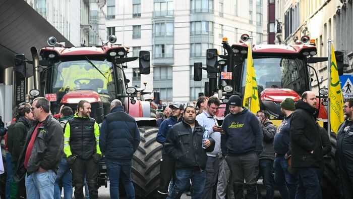 Farmers stand in front of tractors near the European Parliament, during a farmers' protest to denounce the reforms of the Common Agricultural Policy (CAP) and trade agreements such as the Mercosur, in Brussels, on December 18, 2025, organised by Copa-Cogeca, the main association representing farmers and agricultural cooperatives in the EU. EU Farmers, particularly in France, worry the Mercosur deal -- which will be discussed at the EU leaders meeting -- will see them undercut by a flow of cheaper goods from agricultural giant Brazil and its neighbours. They also oppose plans put forward by the European Commission to overhaul the 27-nation bloc's huge farming subsidies, fearing less money will flow their way. (Photo by NICOLAS TUCAT / AFP)