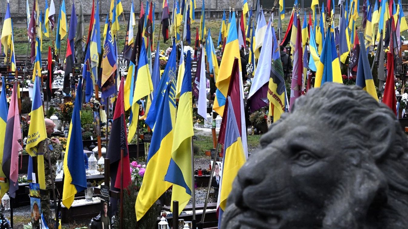 Egy ukrán katona keresztet vet az elesett ukrán katonák sírjai előtt (Fotó: AFP)