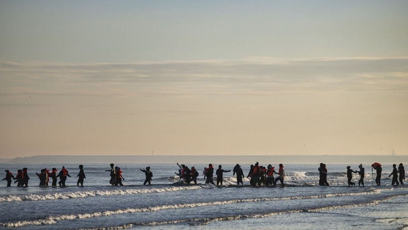 Csempész csónakra igyekvő migráns csoport.