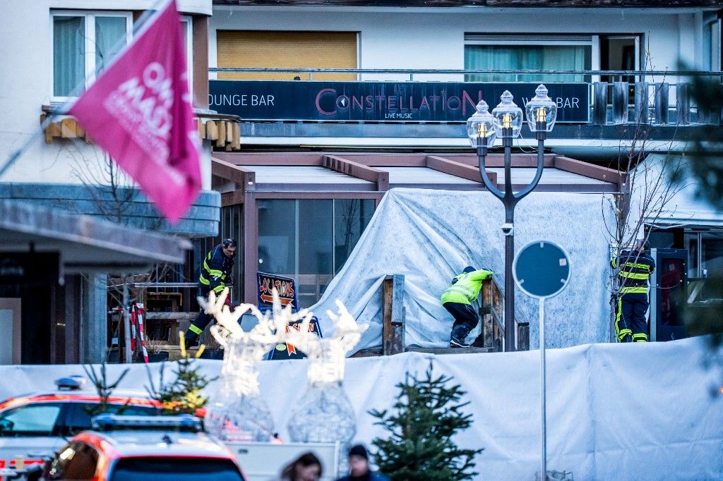 Rescuers and fire-fighters work at the site of an explosion that ripped through the bar Le Constellation in Crans-Montana on January 1, 2026. Several people were killed and others injured when an explosion ripped through a bar in the luxury Alpine ski resort town of Crans Montana, Swiss police said early on January 1. (Photo by MAXIME SCHMID / AFP)