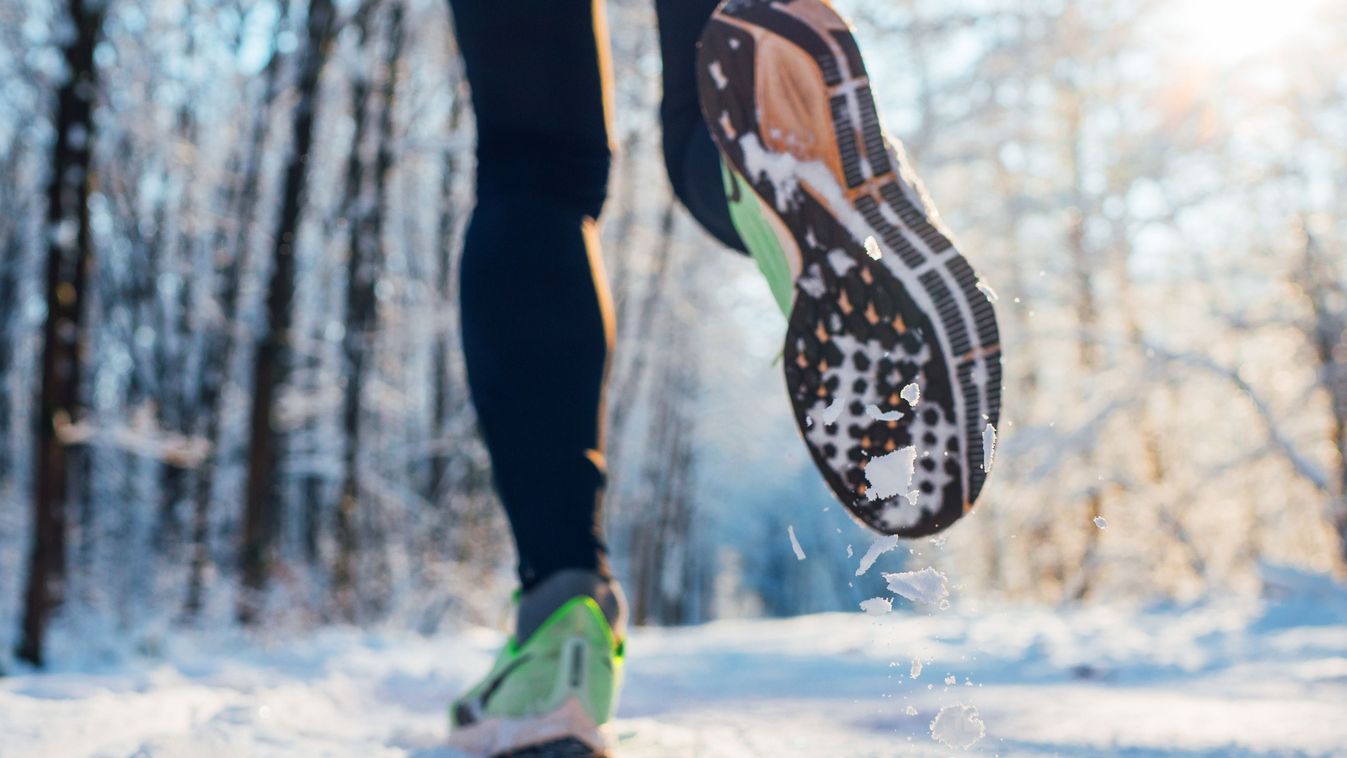 Running shoes sole close up image of winter jogger feet in running sneakers on the snowy park path during sunny day. Rear view sole shot.

2554048527