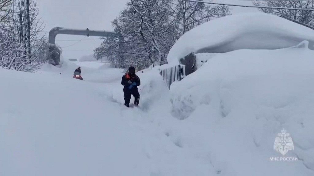 This grab from a handout footage released by the Russian Ministry of Emergency Situations on January 15, 2026, shows Russian rescuers digging houses out from deep snow in the far-east Kamchatka region. Local emergency services declared an emergency situation amid a record snowstorm and said that two people have died over the past 24 hours due to "roof avalanches". Classes were cancelled in schools and many businesses switched to remote working. (Photo by Handout / RUSSIAN EMERGENCY SITUATIONS MINISTRY / AFP) / RESTRICTED TO EDITORIAL USE - MANDATORY CREDIT "AFP PHOTO / Russian Ministry of Emergency Situations" - HANDOUT - NO MARKETING NO ADVERTISING CAMPAIGNS - DISTRIBUTED AS A SERVICE TO CLIENTS