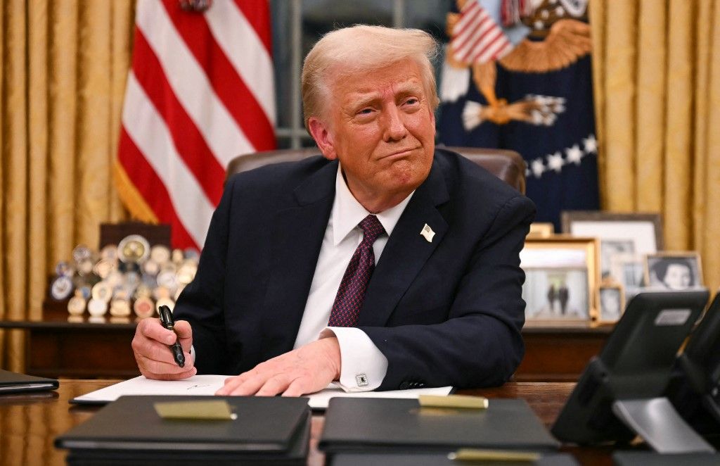 (FILES) US President Donald Trump signs executive orders in the Oval Office of the White House in Washington, DC, on January 20, 2025. One year into his second term, US President Donald Trump is shattering the post-World War II order as never before, leaving a world that may be unrecognizable once he is through. Far from slowing down, Trump has rung in the new year with a slew of aggressive actions that brazenly defy the decades-old order that was championed by the United States. (Photo by Jim WATSON / AFP)