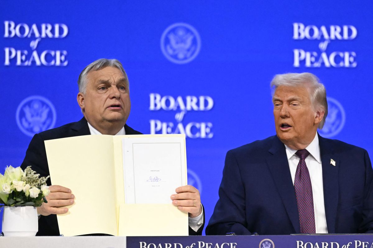 Hungary's Prime Minister Viktor Orban (L) holds a founding charter next to US President Donald Trump at the "Board of Peace" meeting during the World Economic Forum (WEF) annual meeting in Davos on January 22, 2026. US President Donald Trump will show off his new "Board of Peace" at Davos on January 22, 2026 burnishing his claim to be a peacemaker a day after backing off his own threats against Greenland. Originally meant to oversee the rebuilding of Gaza after the war between Hamas and Israel, the board's charter does not limit its role to the Strip, and has sparked concerns that Trump wants it to rival the United Nations. (Photo by Fabrice COFFRINI / AFP)