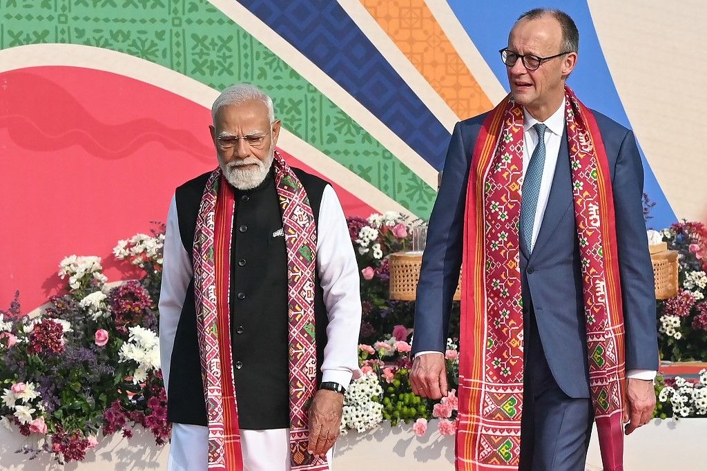 India's Prime Minister Narendra Modi (L) walks alongside German Chancellor Friedrich Merz during the International Kite Festival in Ahmedabad on January 12, 2026. (Photo by Shammi MEHRA / AFP)