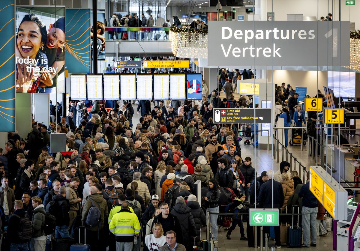 Travelers stand as flights are canceled and delayed due to weather conditions at Schiphol Airport on January 2, 2026. (Photo by Koen van Weel / ANP / AFP) / Netherlands OUT