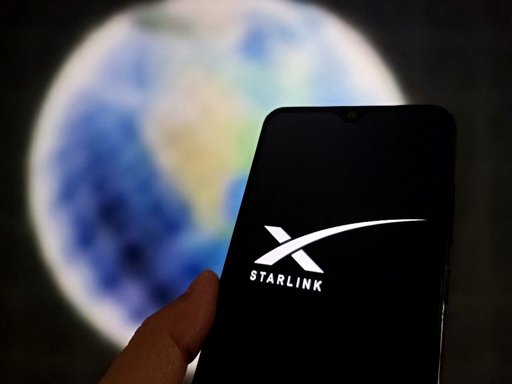 An illustration photo shows STARLINK logo in a smartphone in Suqian, Jiangsu, China on October 16, 2025. (Photo by Guo Dexin / CFOTO via AFP)