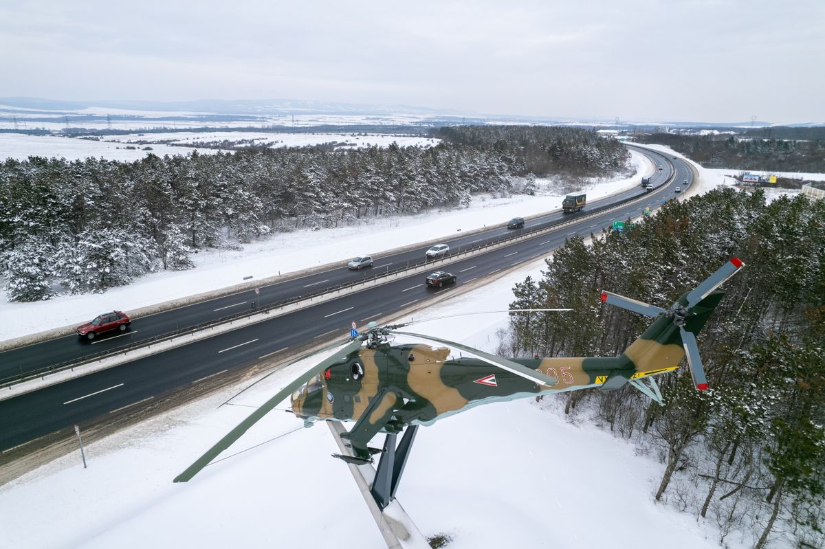 Veszprém, 2026. január 7.
A drónnal készült felvételen a hótól megtisztított M8-as autóút Veszprém határában, az előtérben egy kiállított Mi 24-es katonai helikopter 2026. január 7-én.
MTI/Máthé Zoltán