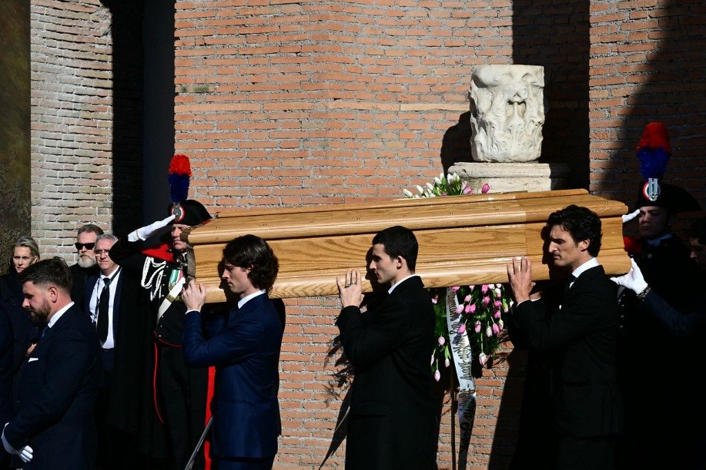 Relatives carry the coffin of the late Italian fashion designer Valentino Gavarani after the funeral ceremony at the Basilic of Santa Maria degli Angeli e dei Martiri in Rome on January 23, 2026. (Photo by Stefano RELLANDINI / AFP)