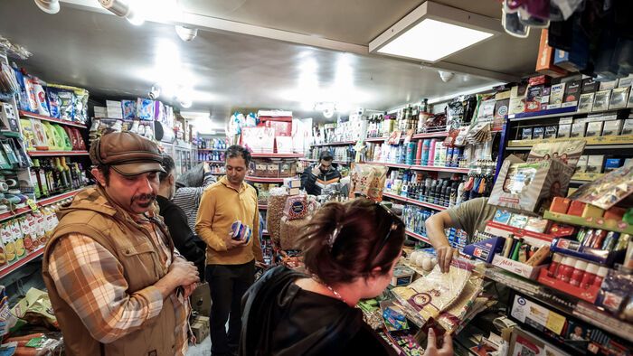 People shop for groceries in a store in Tehran on February 28, 2026. The United States and Israel launched strikes against Iran on February 28, with Israel's public broadcaster reporting that supreme leader Ayatollah Ali Khamenei had been targeted, as the Islamic republic retaliated with barrages of missiles at Gulf states and Israel. (Photo by Atta KENARE / AFP)