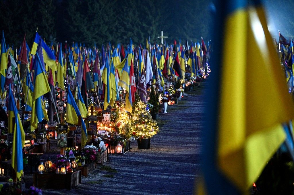 A photograph taken on December 23, 2025 shows a graves of fallen Ukrainian soldiers decorated with Christmas trees and New Year's decorations at the Lychakiv Military Cemetery on the day before Christmas Eve, in Lviv, amid the Russian invasion of Ukraine. (Photo by YURIY DYACHYSHYN / AFP)